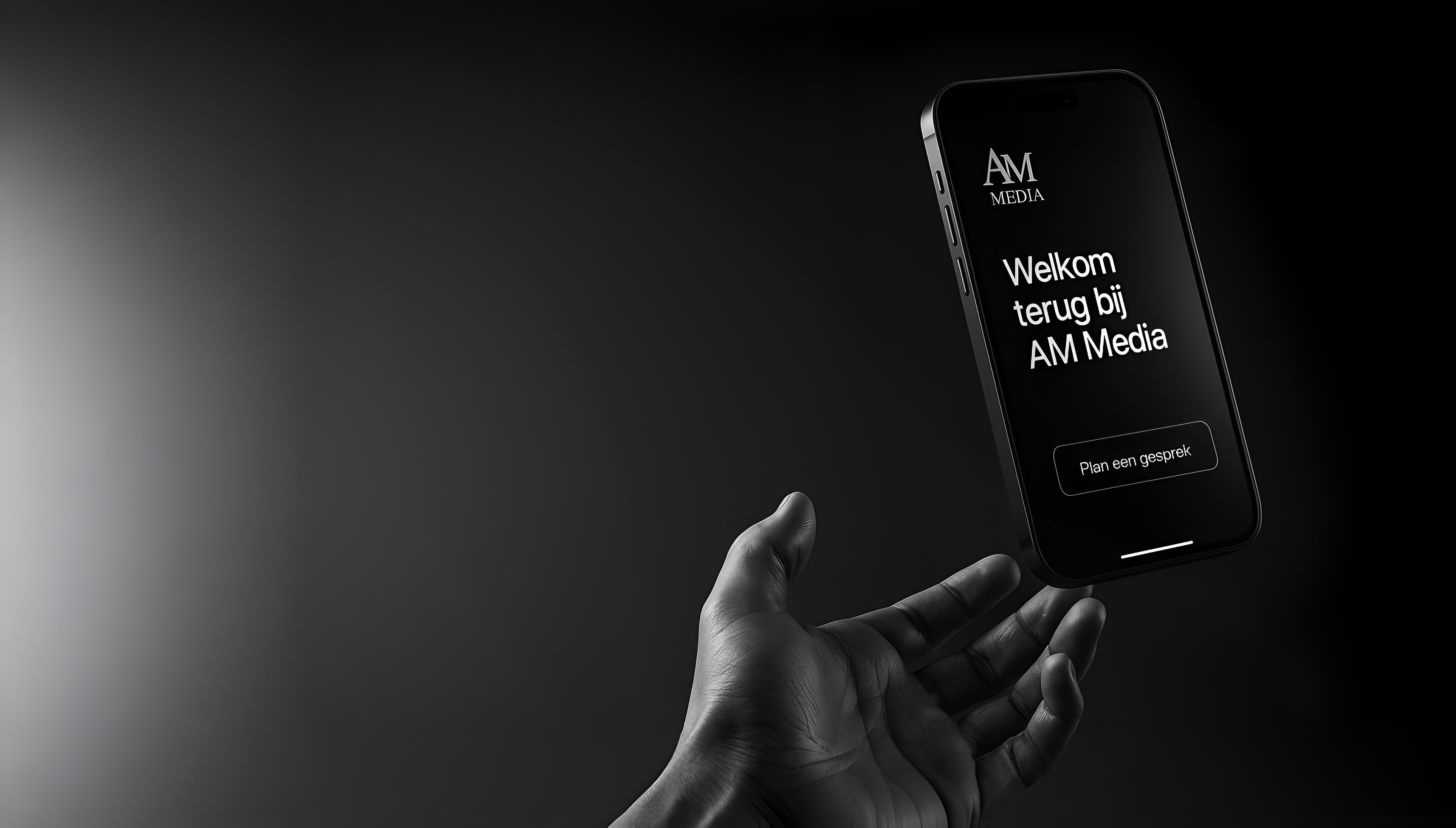 Hand holding phone with AM Media branding