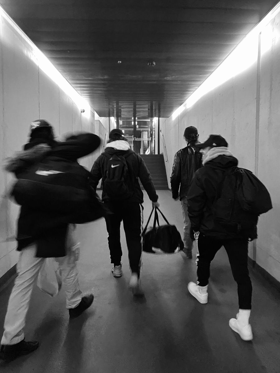 Team members walking together through urban tunnel